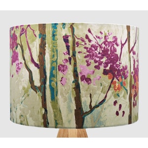 May include: A lampshade with a floral pattern featuring pink, green and brown colours. The pattern resembles a woodland scene with trees and flowers.