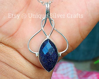 May include: A silver pendant necklace with a dark blue, faceted gemstone. The pendant is teardrop-shaped and hangs from a delicate silver chain. The image includes the text "Etsy @ Unique Silver Crafts".