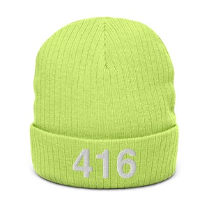May include: A lime green knitted beanie with a white embroidered number "416" on the front.