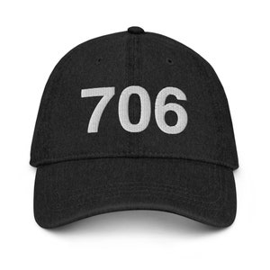 May include: A black denim baseball cap with the number 706 embroidered in white on the front.