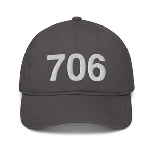 May include: A dark grey baseball cap with the number 706 embroidered in white on the front.