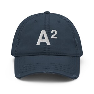 May include: A navy blue distressed baseball cap with a white embroidered "A²" on the front.