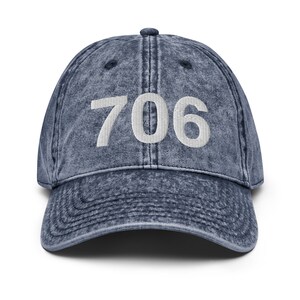 May include: A blue denim baseball cap with the number 706 embroidered in white on the front.
