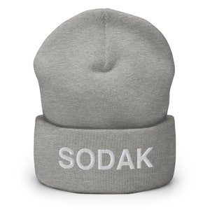May include: Gray beanie with a white embroidered word "SODAK" on the cuff.