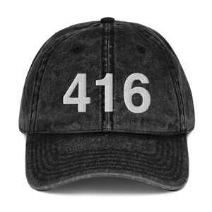 May include: Black vintage style baseball cap with the number 416 embroidered in white on the front.