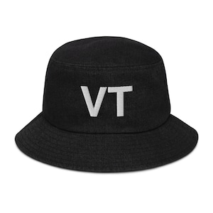Pode incluir: Chapéu de pescador preto com um "VT" branco bordado na frente.