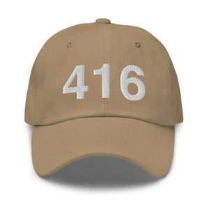 May include: A tan baseball cap with the number "416" embroidered in white on the front.