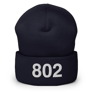May include: A navy blue beanie with a white embroidered number "802" on the front.