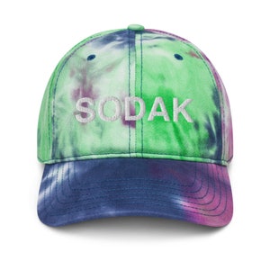 Peut inclure: Une casquette de baseball en tie-dye vert, bleu et violet avec le mot "SODAK" brodé en blanc sur le devant.