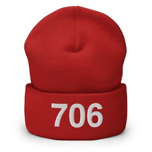 May include: Red knitted beanie with a white embroidered number 706.