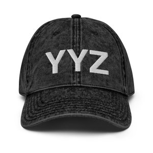 May include: A black vintage washed cotton baseball cap with the text "YYZ" embroidered in white on the front.