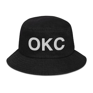 Pode incluir: Chapéu de pescador preto com o texto "OKC" bordado em branco na frente.