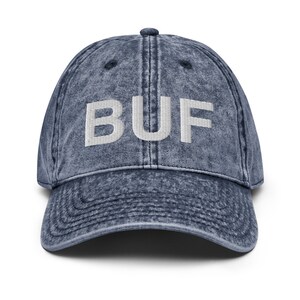 May include: A blue denim baseball cap with a white embroidered "BUF" on the front.