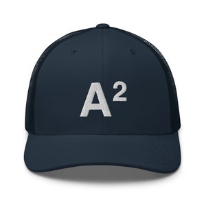 May include: A navy blue trucker hat with a white mesh back and a white embroidered "A²" logo on the front.