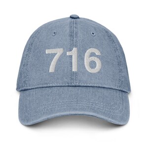 May include: A blue denim baseball cap with the number 716 embroidered in white on the front.