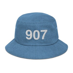 May include: A blue denim bucket hat with the number 907 embroidered in white on the front.