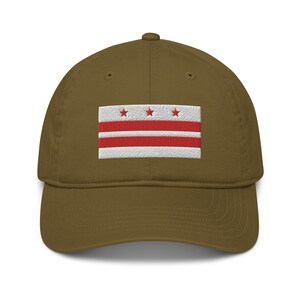 May include: A brown baseball cap with an embroidered District of Columbia flag. The flag is white with three red stars and two red stripes.