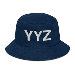 Pode incluir: Um chapéu de pescador azul marinho com um logotipo "YYZ" bordado em branco.