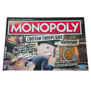 Könnte beinhalten: Eine Monopoly Mogeln & Mauscheln Brettspielschachtel mit dem Monopoly-Logo in Rot und Weiß. Die Schachtel zeigt eine Zeichentrickfigur mit weißem Schnurrbart, eine Gefängnisgrafik und ein durch ein Sichtfenster sichtbares Handschellenspielzeug.