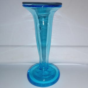 May include: A tall, slender, light blue glass vase with a flared top and a round base.