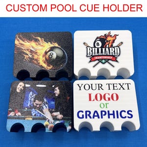 May include: Four rectangular pool cue holders with three circular cutouts each. Two holders are black with printed graphics of a flaming eight ball and people playing billiards. Two holders are white with a billiard championship logo and text.