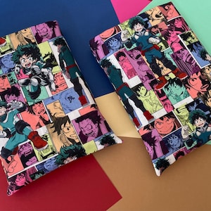 May include: Two white fabric pillow covers with a colorful anime print featuring a green-haired character. The print is a collage of different scenes and characters from the anime.