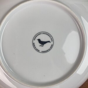 May include: White ceramic plate with a black bird logo that reads "Dishwasher & Microwave Safe. Made in Japan. Fabrique au Japon."