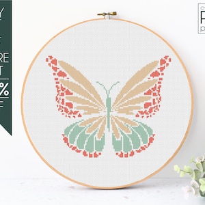 May include: A cross-stitch pattern of a butterfly with peach, coral, and green wings. The pattern is displayed in a wooden embroidery hoop.