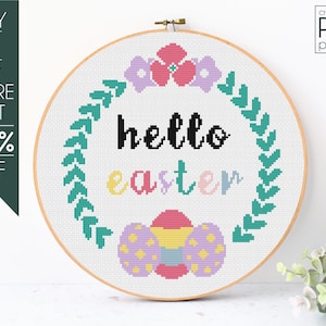 Puede incluir: Un bastidor de bordado de punto de cruz con las palabras "hello easter" en negro y colores pastel. El diseño incluye un borde de hojas verdes, flores y huevos de Pascua. El texto "cross-stitch PDF pattern" está en la esquina superior derecha.