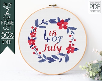 May include: Cross-stitch pattern for a 4th of July wreath with red flowers and blue leaves. The text reads "4th of July".