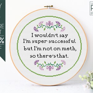 Pode incluir: Padrão de ponto cruz PDF para um aro com um design floral e o texto "Eu não diria que sou super bem-sucedida, mas não estou em metanfetamina, então é isso."