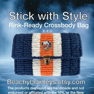May include: A navy blue, white, and orange crossbody bag with a metal clasp. The bag features the text "Stick with Style Rink-Ready Crossbody Bag" and a logo. The bag is handmade.