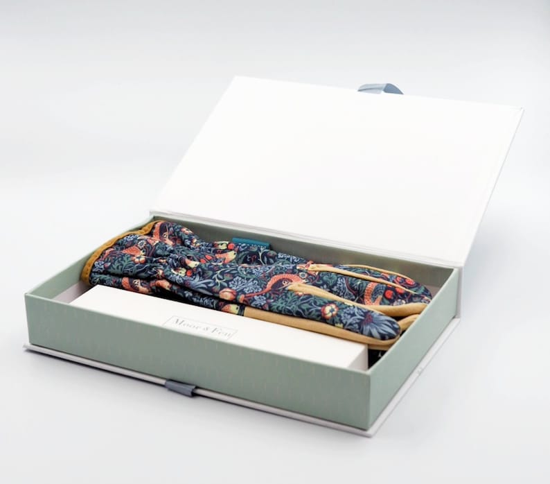 May include: A green and white box with a floral patterned gardening glove inside. The box is open and the glove is visible. The box has the text "Mouse & Feet" on the front.