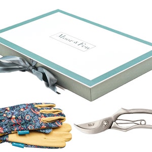May include: A gardening gift set in a light blue and white box with a gray ribbon. The set includes a pair of floral patterned gardening gloves and a pair of silver pruning shears with the text "M&F" on the handle.
