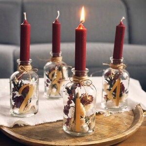 Modern Advent wreath made of candle jars and dried flowers