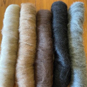 Può includere: Sei rotoli di fibra naturale in varie tonalità di beige, marrone e grigio. I rotoli sono cilindrici e hanno un aspetto morbido e strutturato. I colori vanno dal crema chiaro al carbone scuro.
