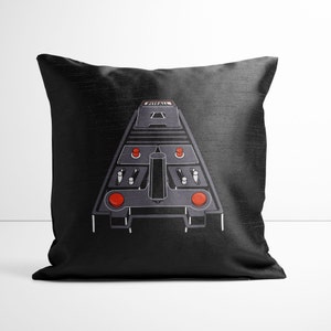May include: Black throw pillow with a white outline of a vintage video game controller with the word "PITFALL!" printed on the top. The controller has red buttons and a joystick.