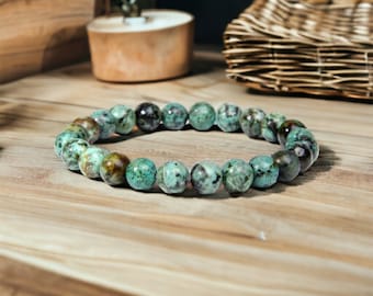 May include: A turquoise gemstone bracelet with round beads. The bracelet is made of natural stones and has a rustic look.
