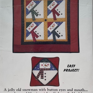 May include: A package featuring a snowman quilt pattern. The design includes four snowman blocks with colorful scarves and hats, set against a red and black border. The text "SNOWMAN PATCHES" is at the top.