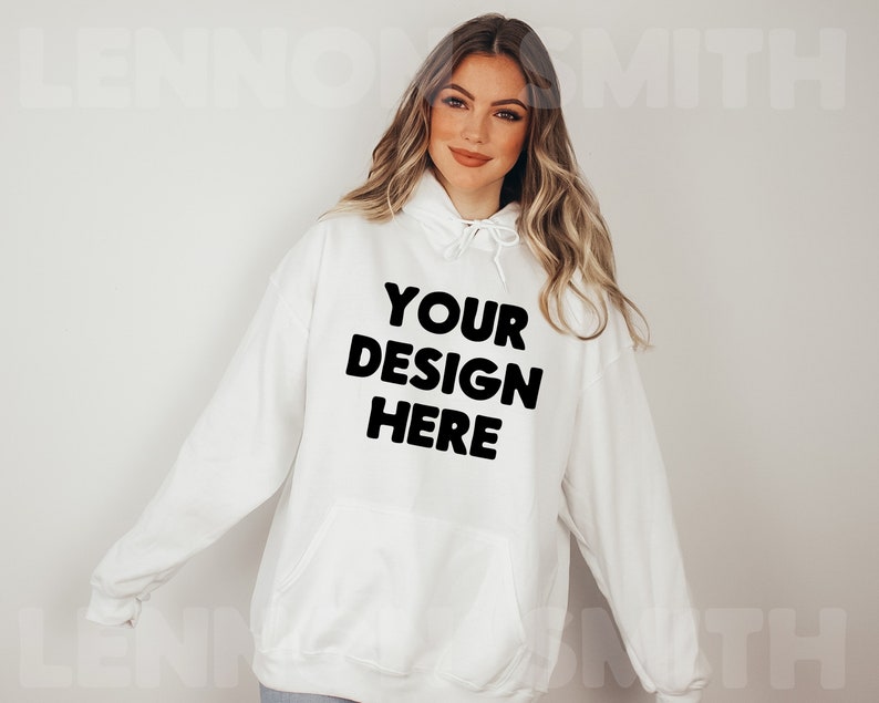 Może przedstawiać: Biała bluza z kapturem z nadrukiem "YOUR DESIGN HERE" w kolorze czarnym.