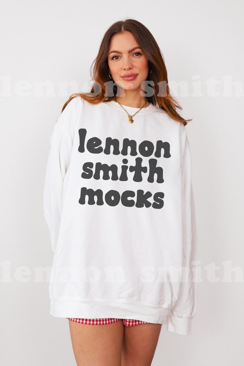 Może przedstawiać: Biała bluza z czarnym napisem "lennon smith mocks" w retro czcionce.