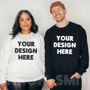 May include: Two people wearing black and white sweatshirts with the text "YOUR DESIGN HERE" printed on the front. The person on the left is wearing a white sweatshirt and the person on the right is wearing a black sweatshirt.