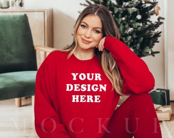 May include: A woman wearing a red long-sleeved sweatshirt with the text "YOUR DESIGN HERE" printed on the front. The sweatshirt is a blank canvas for customization.