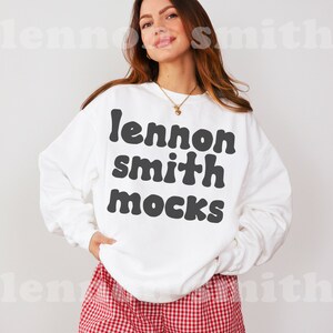 Może przedstawiać: Biała bluza z czarnym napisem "lennon smith mocks" na kobiecie w czerwono-białych szortach w kratkę.