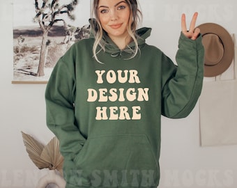 May include: A green hooded sweatshirt with the text "YOUR DESIGN HERE" in a light yellow color.