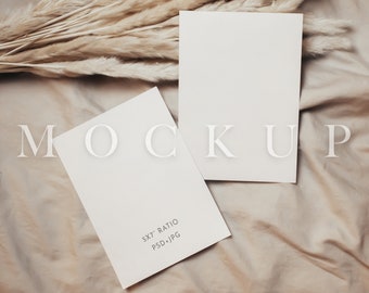 May include: Two blank white cards on a beige fabric background with a dried grass bouquet. The smaller card has the text "5x7" Ratio PSD+JPG" printed on it.