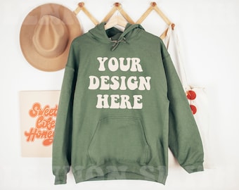 May include: A green hooded sweatshirt with the text "YOUR DESIGN HERE" in a retro font on the front.