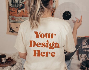 May include: A white t-shirt with the text "Your Design Here" in orange on the back. The shirt is being worn by a person holding a vinyl record.