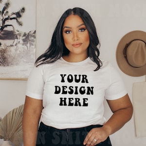 Pode incluir: Camiseta branca com texto preto que diz "YOUR DESIGN HERE" em uma fonte retr&ocirc;.