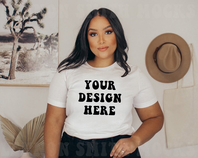 Pode incluir: Camiseta branca com texto preto que diz "YOUR DESIGN HERE" em uma fonte retr&ocirc;.